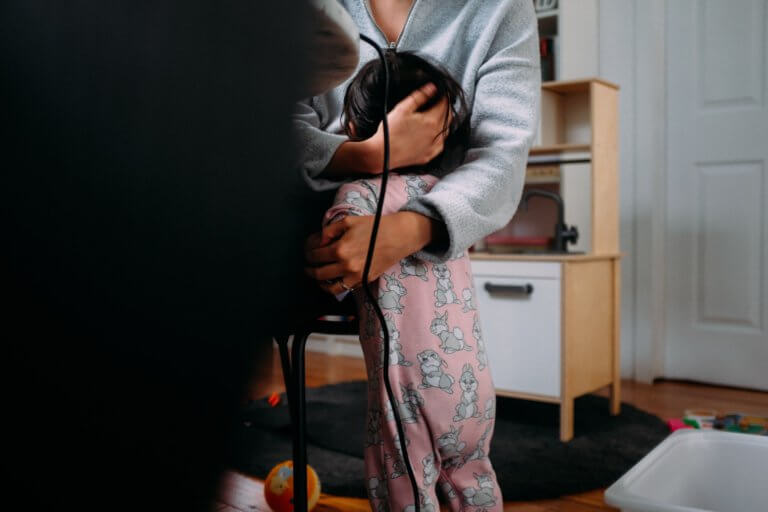 A woman studying from home while also taking care of her newborn.